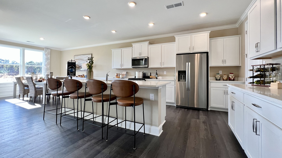 The open-concept great room with a tray ceiling leads you to the gourmet kitchen with an expansive island with quartz countertops.