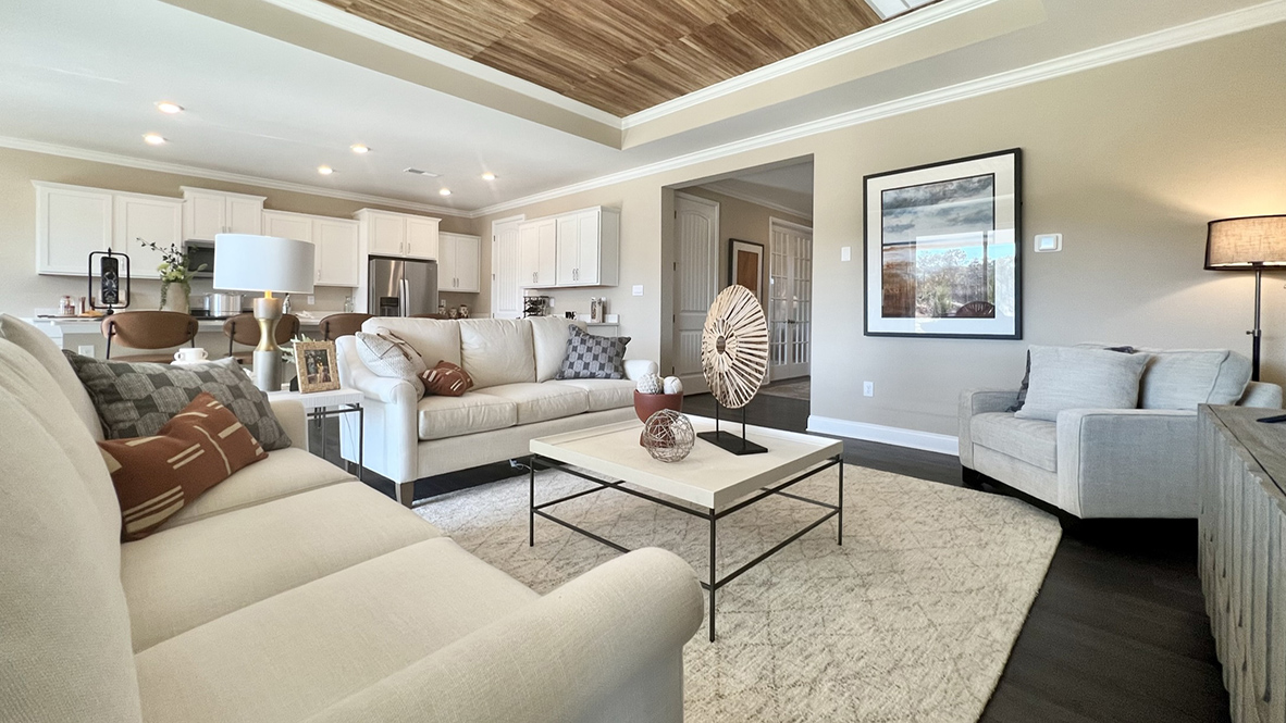 The open-concept great room with a tray ceiling leads you to the gourmet kitchen with an expansive island.