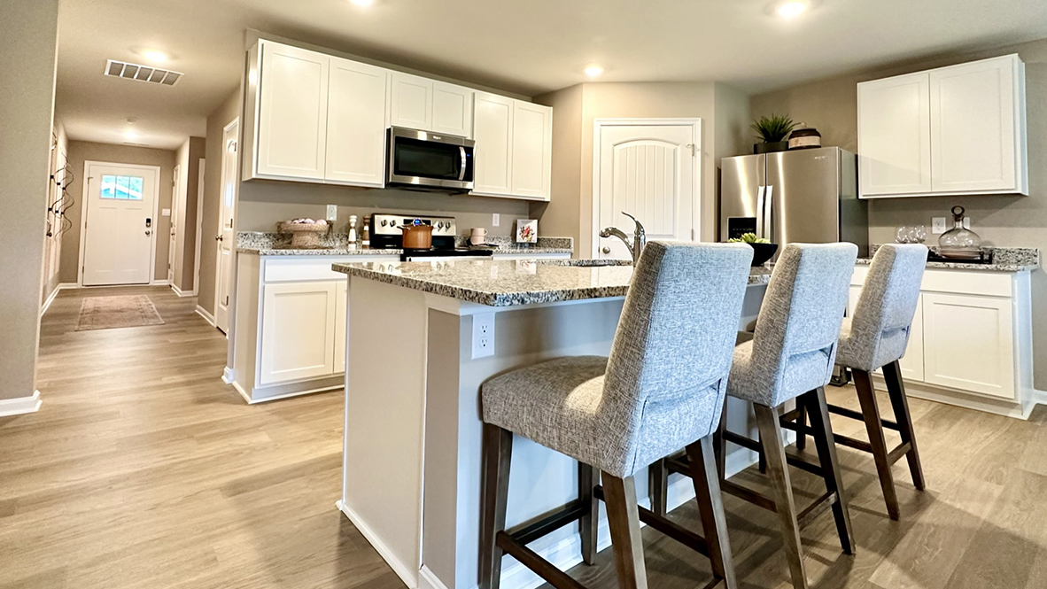 The open-concept kitchen has bright kitchen cabinets.