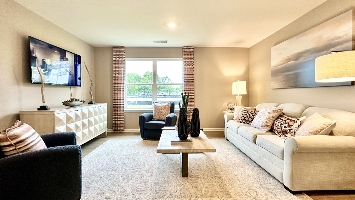 The cozy living area has a double window and laminate plank flooring.