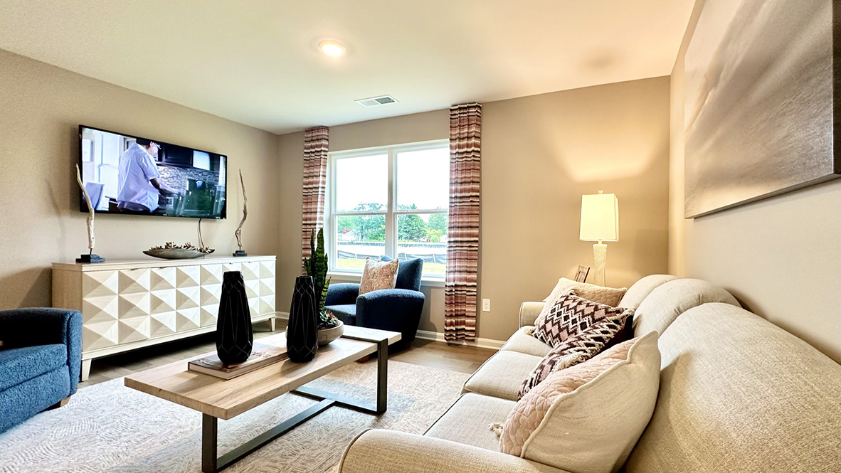 The cozy living area has a double window and laminate plank flooring.