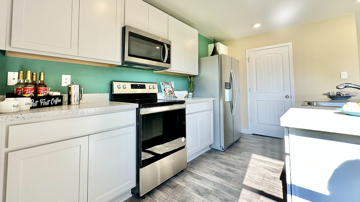 The kitchen has laminate plank flooring.