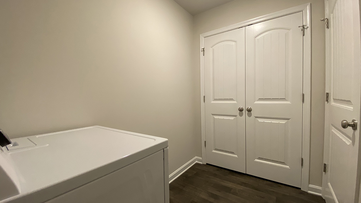 The laundry room is complete with a washer and dryer.