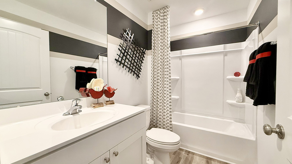 Just off the foyer, two spacious guest bedrooms and a shared full bathroom offer comfort and privacy for family or visitors.