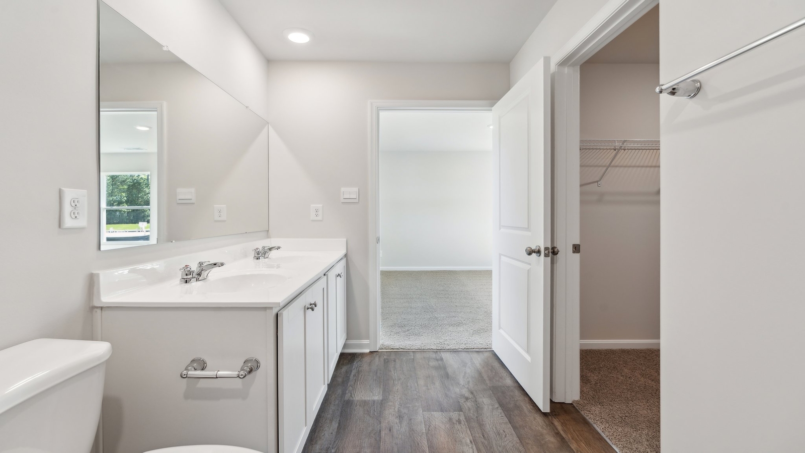 The private bathroom has a double bowl vanity, shower, and an impressive walk-in closet.