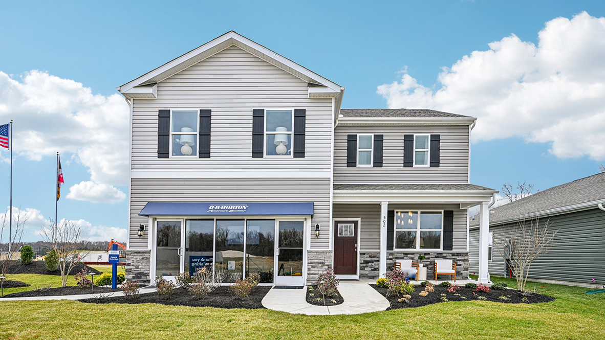 A two-story Galen model home with blue siding and black shutters.