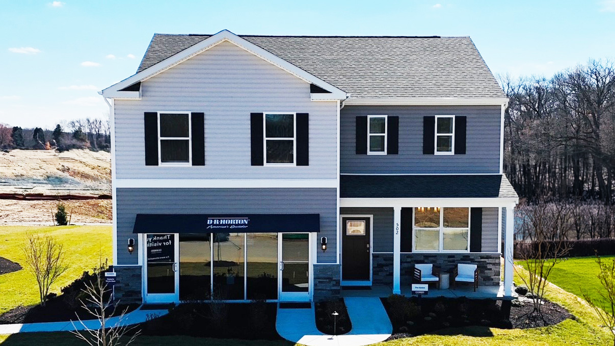 A two-story Galen model home with blue siding and black shutters.