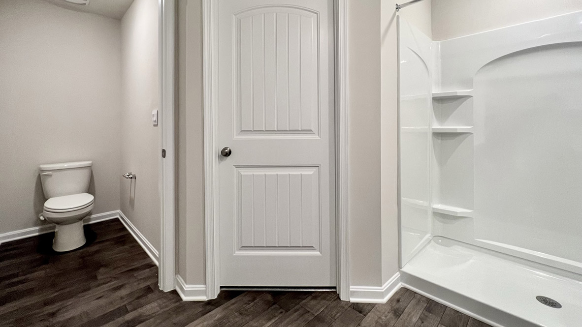 The oversized owner’s bathroom with a double vanity, a walk-in shower and a toilet closet.
