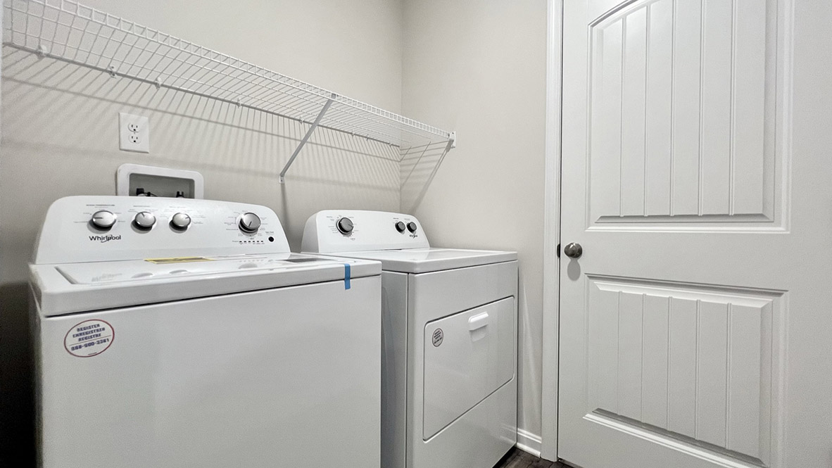 The laundry room is complete with a washer and dryer.