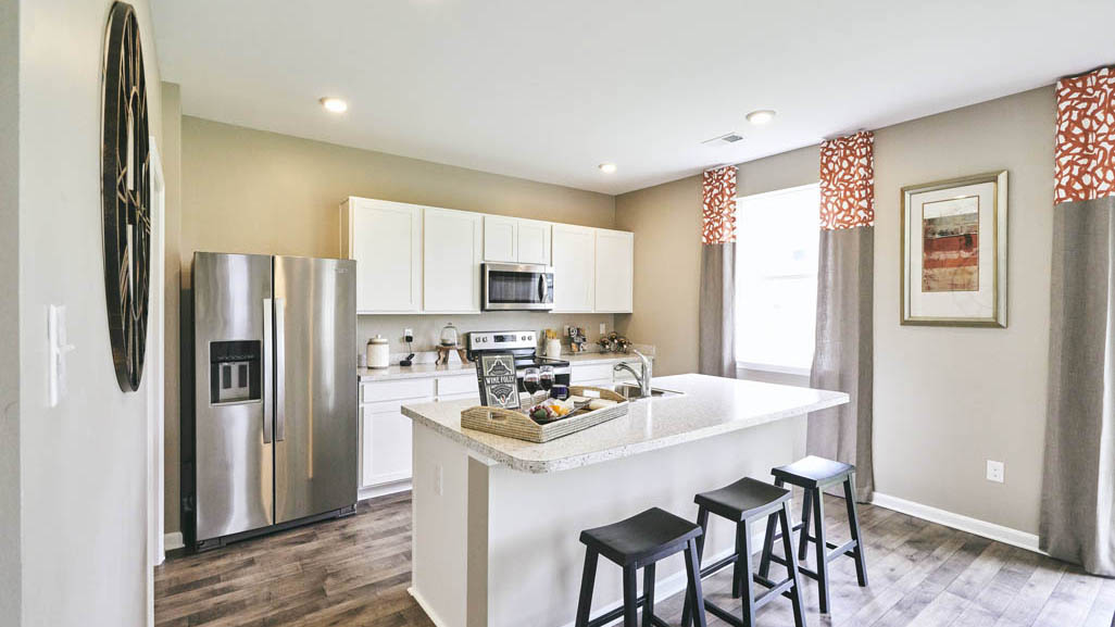 The well-designed gourmet kitchen features a spacious island with additional room for seating.
