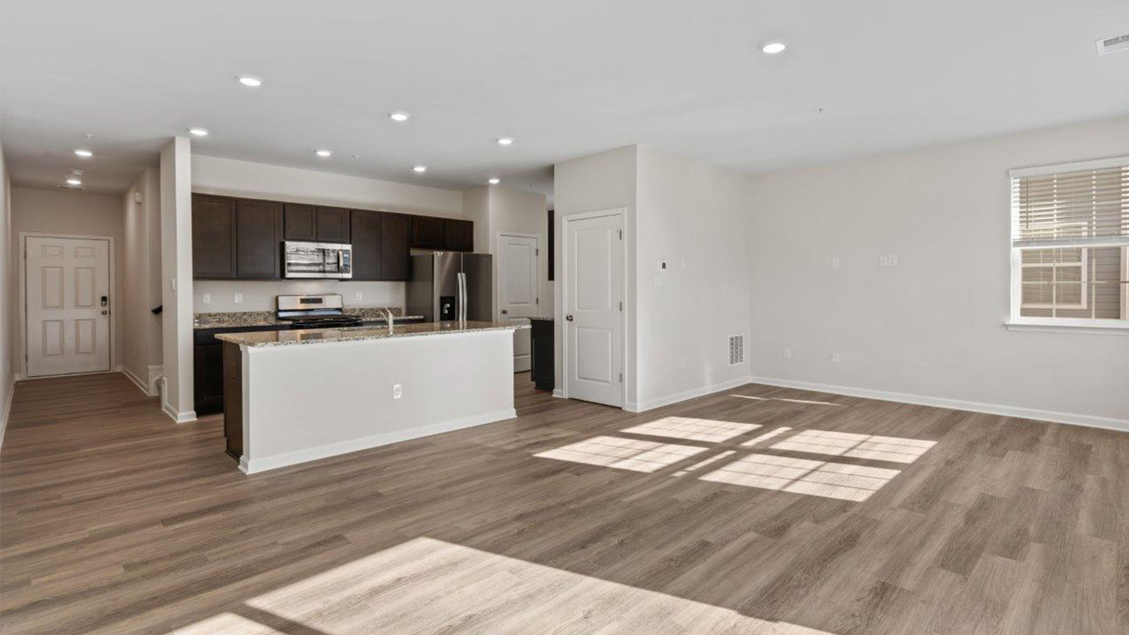 open concept kitchen with island overlooking living
