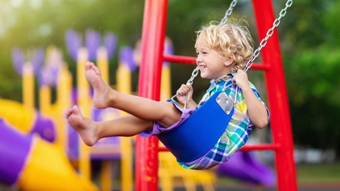 child swinging on swings