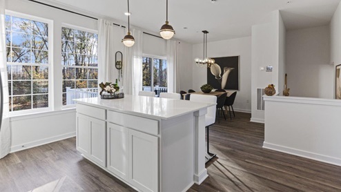 main level kitchen with island seating and pendant lights