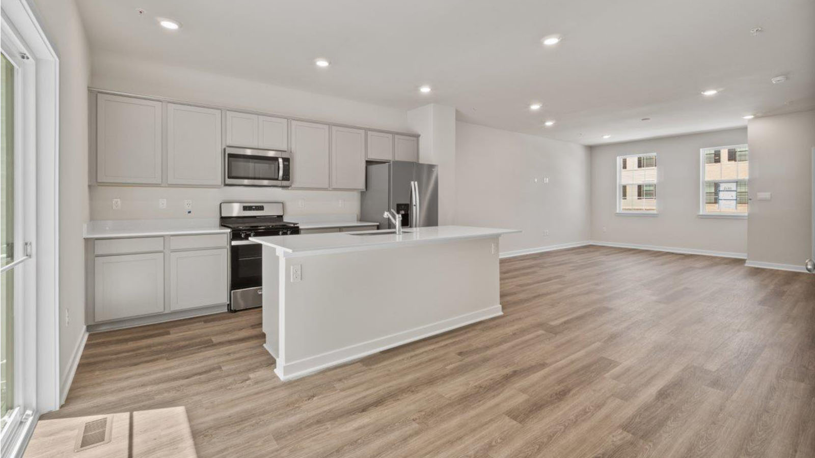 main level kitchen with white shaker style cabinets ND QUARTZ COUNTERS