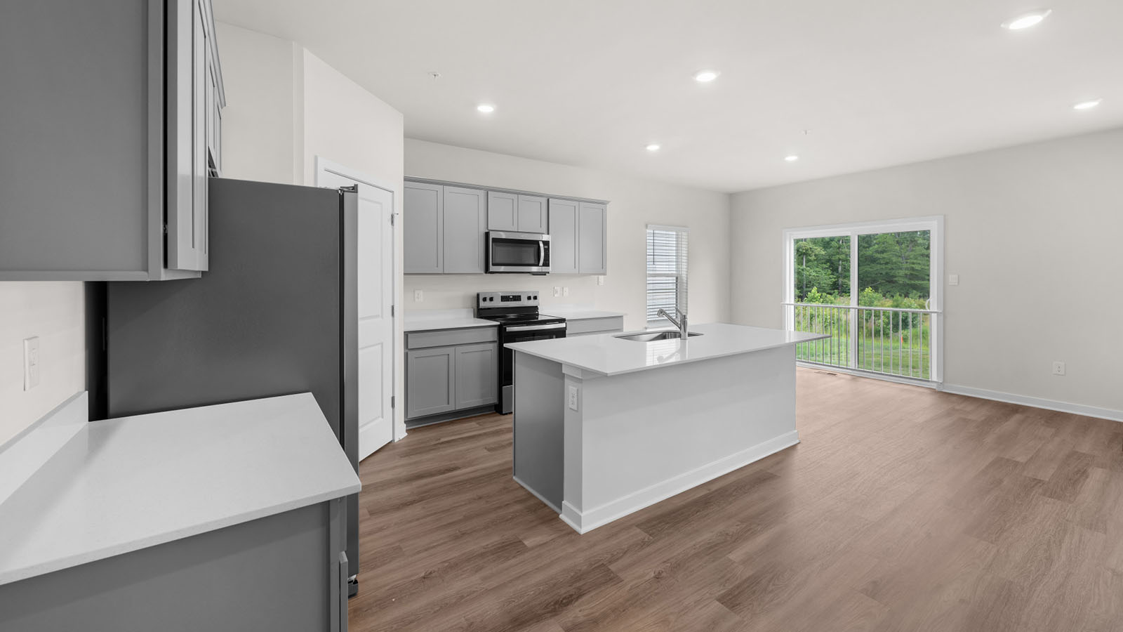 spacious kitchen with grey cabinets and central island seating