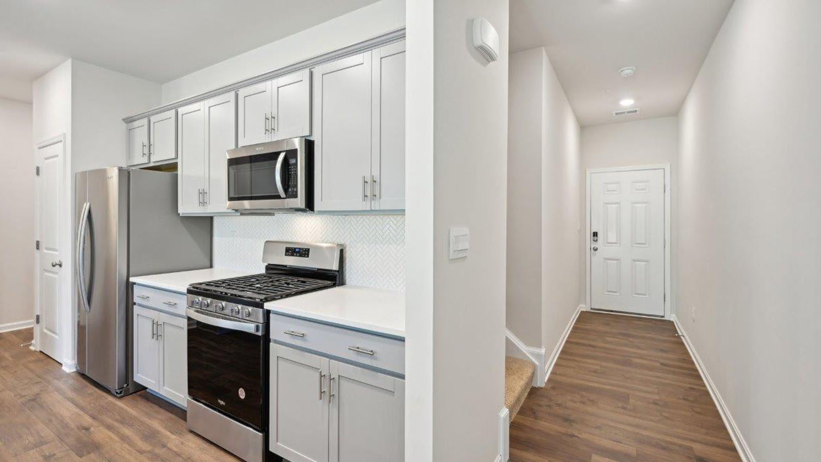 front door leading to open concept kitchen and living