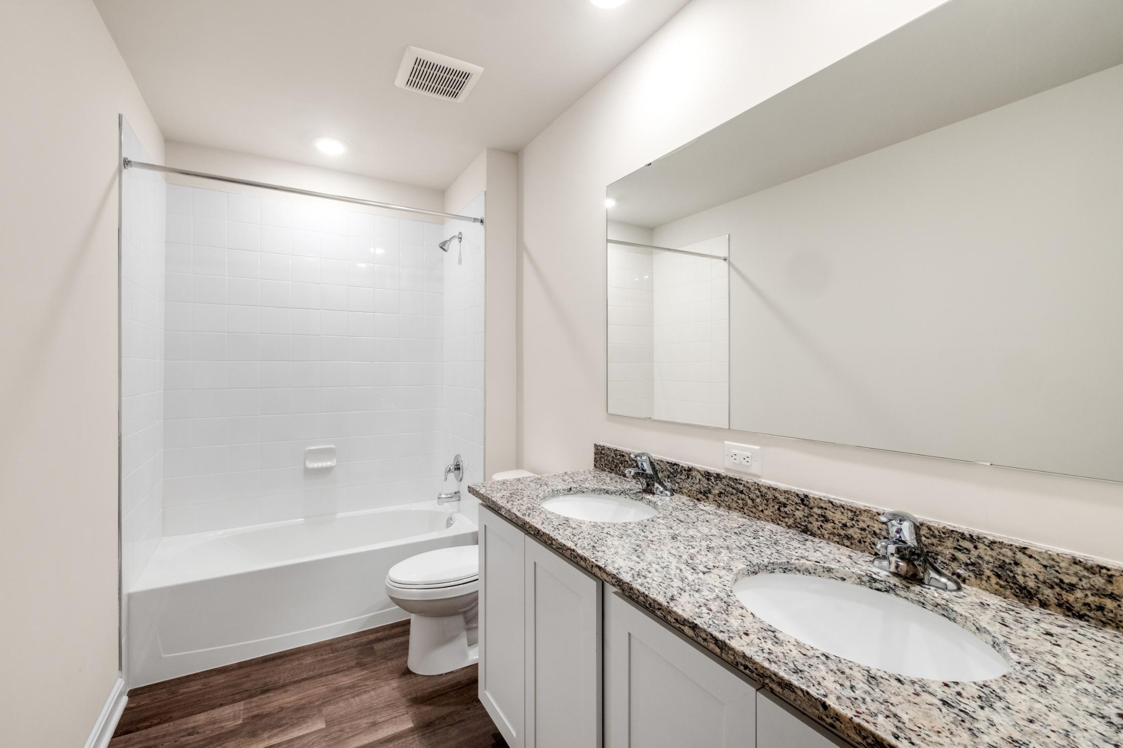 Galen plan bathroom sinks, mirror, toilet and tub with shower