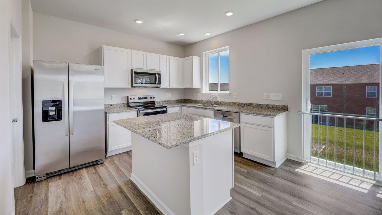 kitchen with white shaker cabinets and central granite island