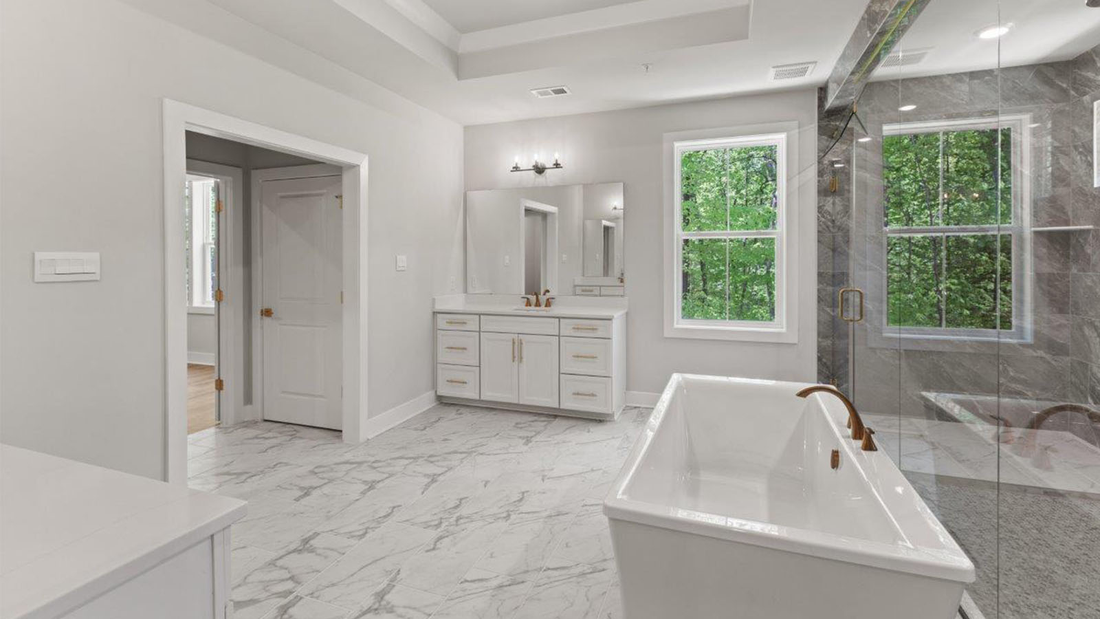 master bathroom with central soaking tub and large glass shower