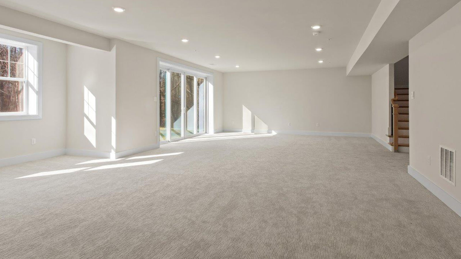 finished basement rec room with large windows and back door access