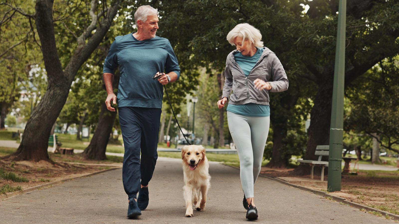 active adult couple walking dog