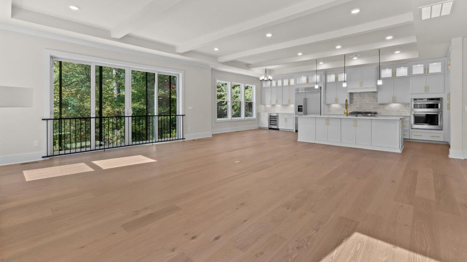 open concept living room with large windows overlooking backyard