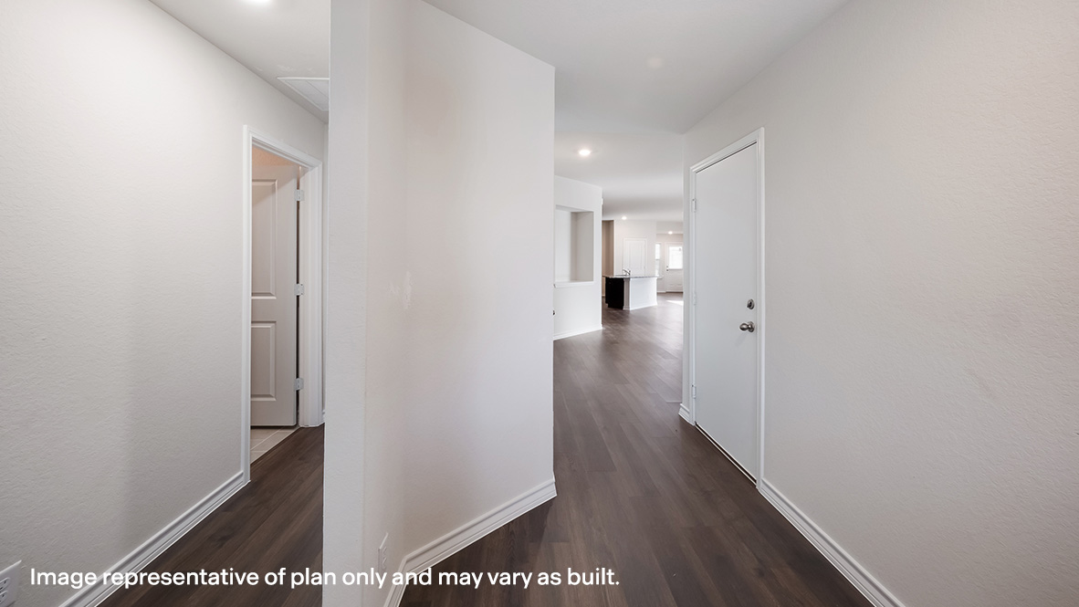 Entryway leading into decorative wall nook and open-concept family area.
