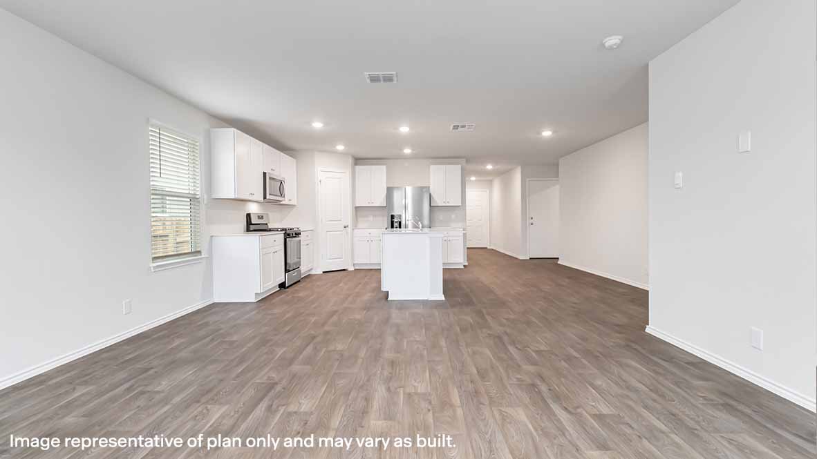 Open concept dining and kitchen space with neutral walls and wood flooring