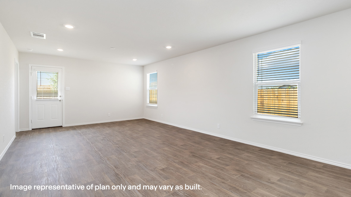 Open concept dining and living room with hard surface flooring and windows throughout.