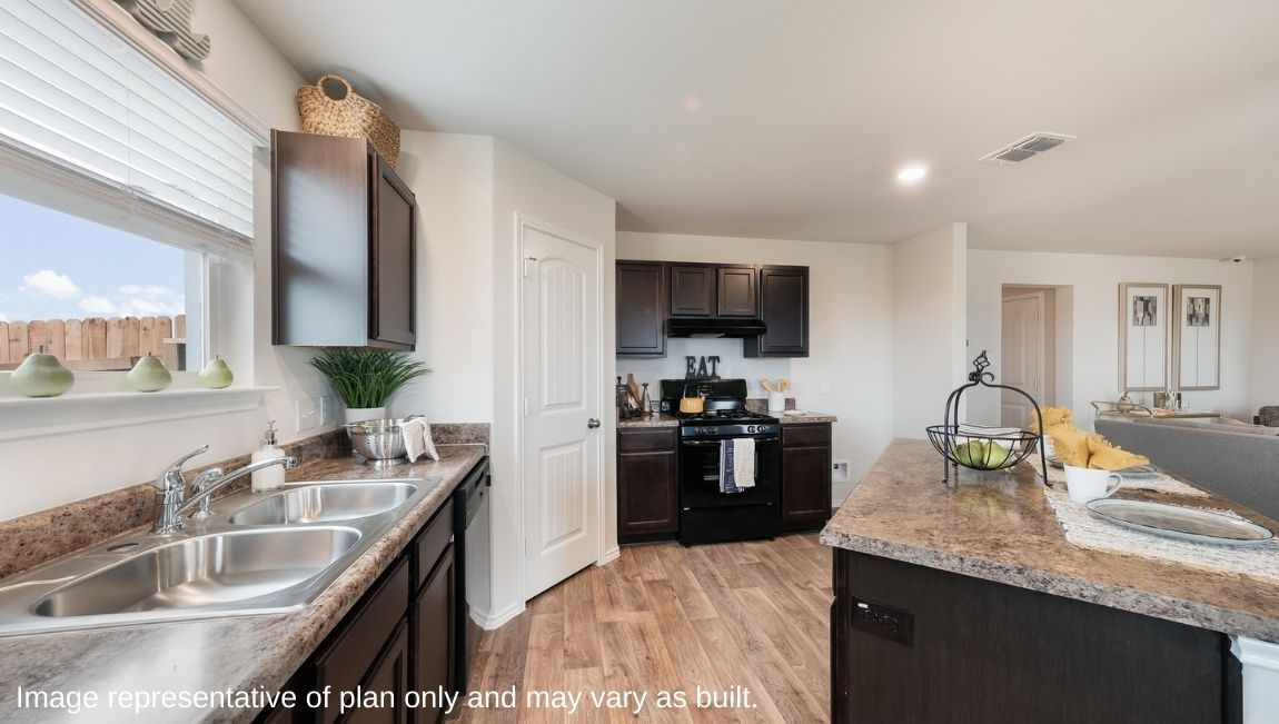 Open-concept kitchen with window above sink and large island.