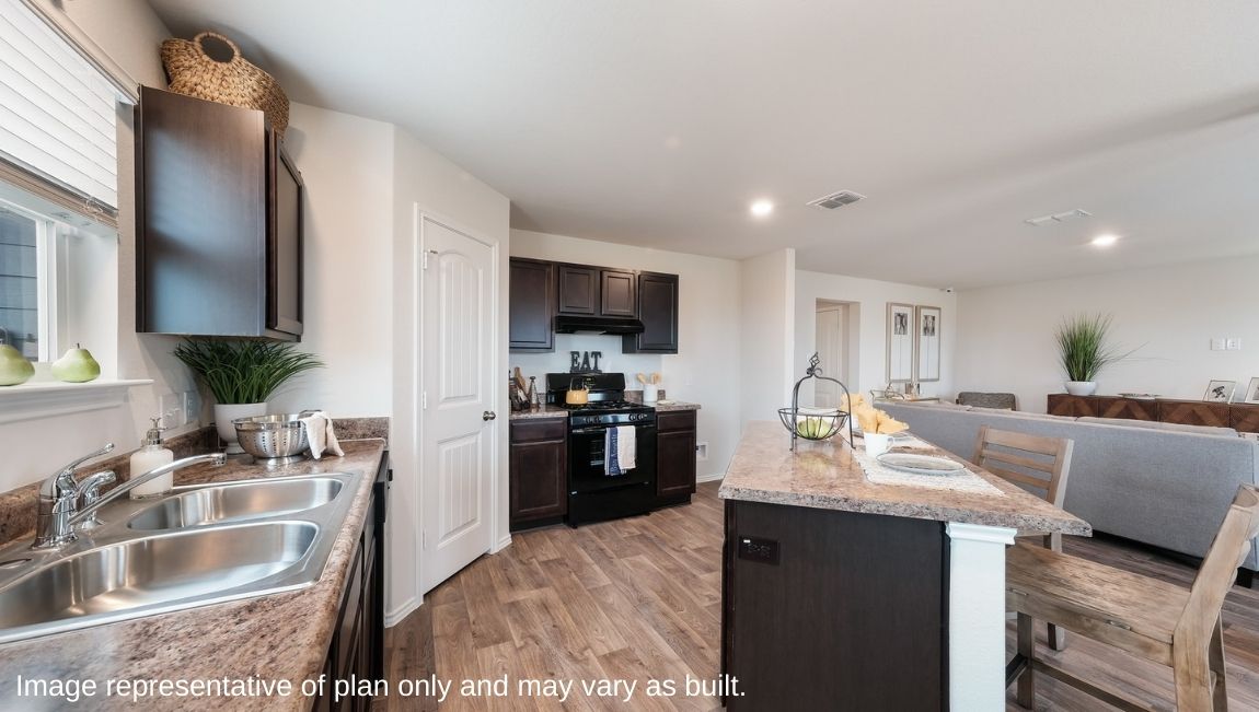 Open-concept kitchen with window above sink and large island.