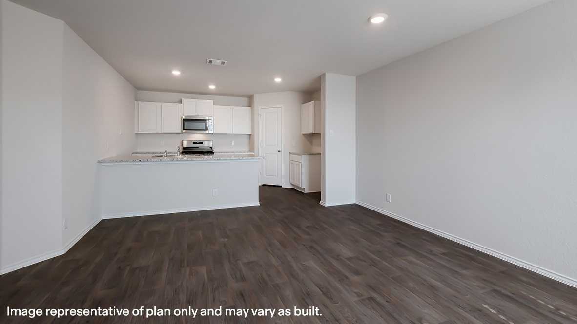 Spacious kitchen with hard surface flooring, plenty of counterspace and cabinet storage overlooking the blended dining and living area.