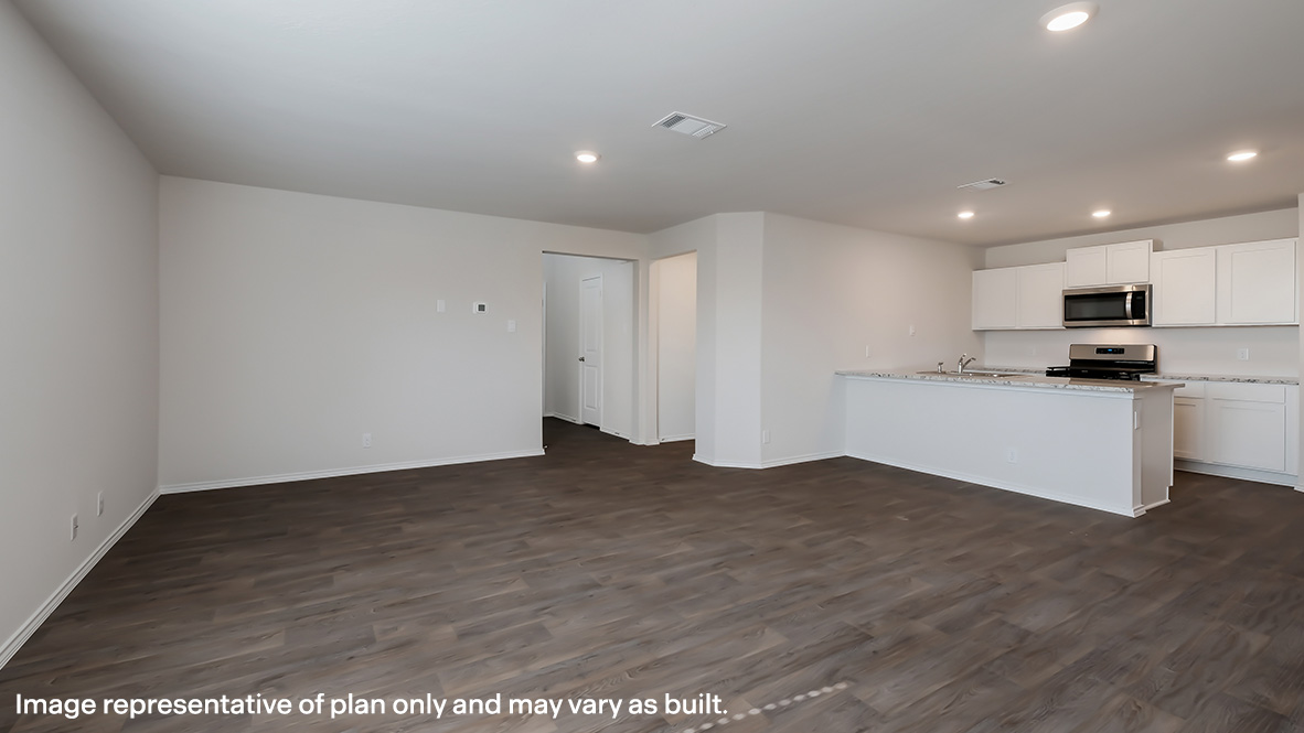 Living room flowing into kitchen area with hard surface flooring and large kitchen bar.