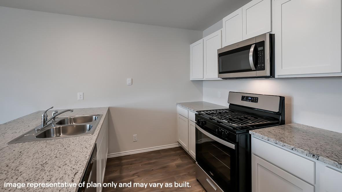 Kitchen with quartz or quartz countertops, stainless steel appliances and shaker style cabinetry.