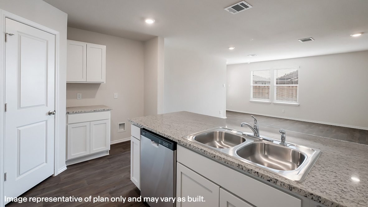 Open-concept kitchen with peninsula and spacious pantry.