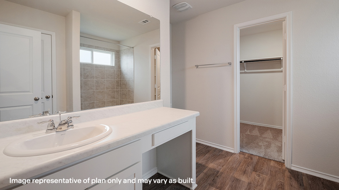 primary ensuite bathroom with single vanity sink and walk in closet