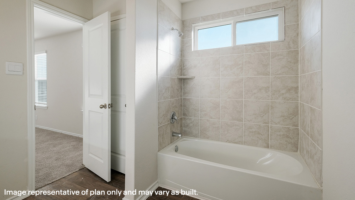 Spacious primary bathroom with combined tub and shower.