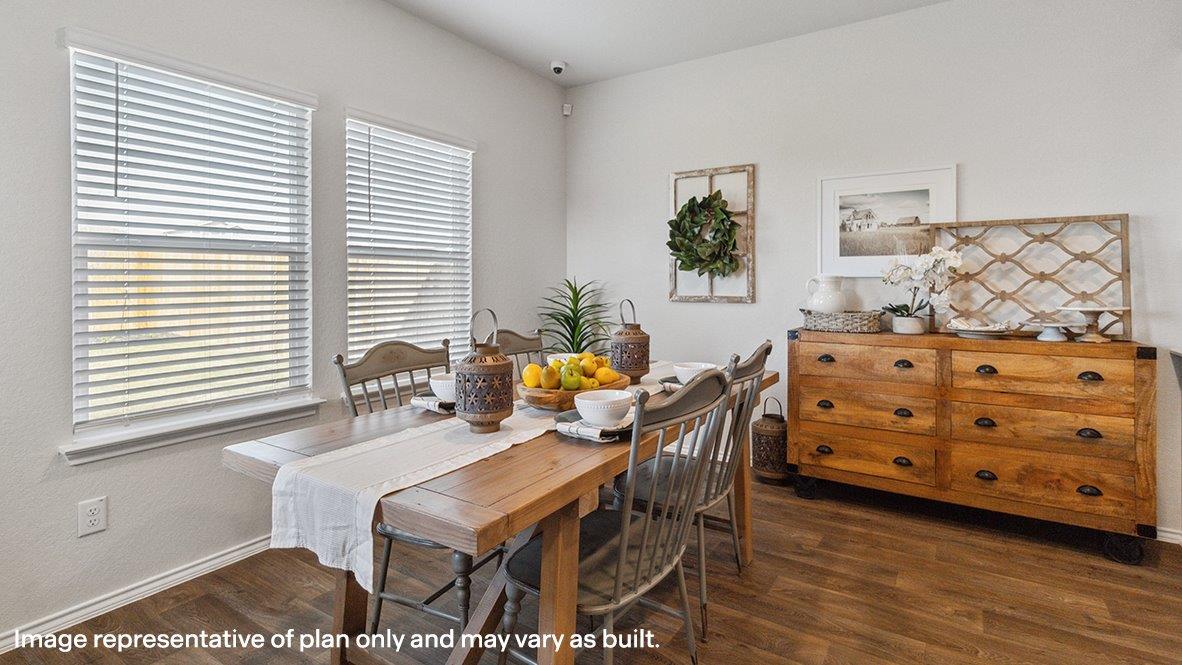 Open-concept dining area overlooking spacious kitchen with hard surface flooring.