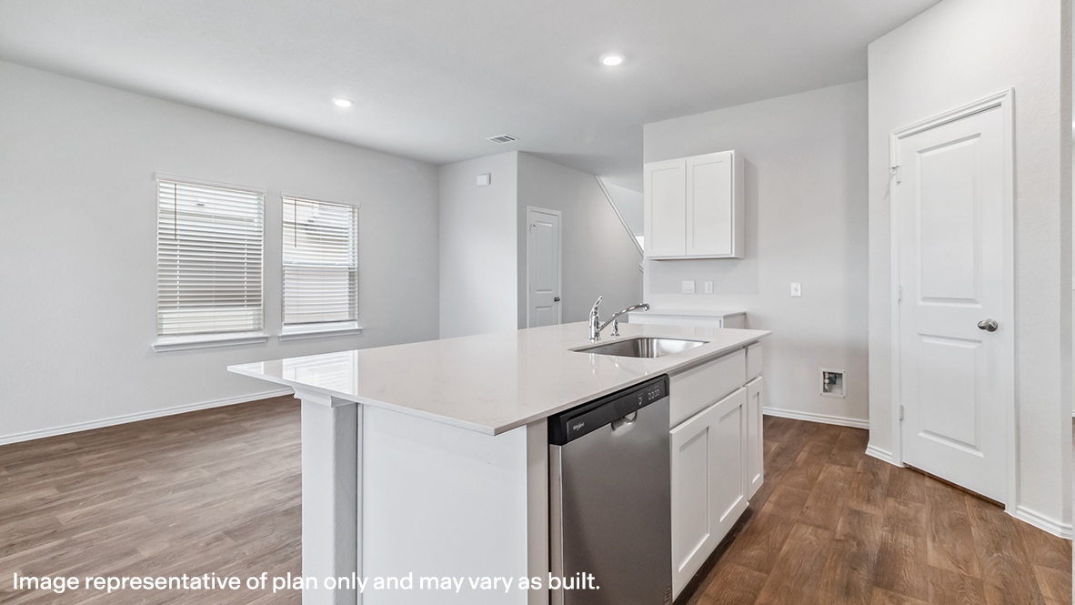 Open-concept dining area facing spacious kitchen with hard surface flooring.