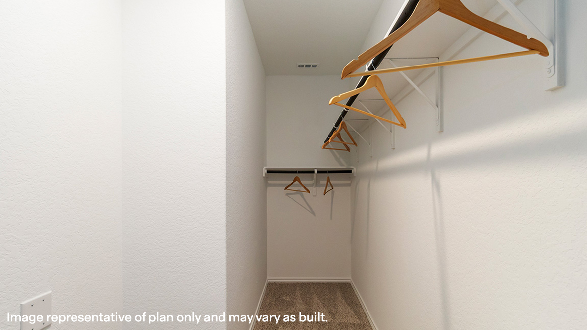 Primary closet with carpeted floors.