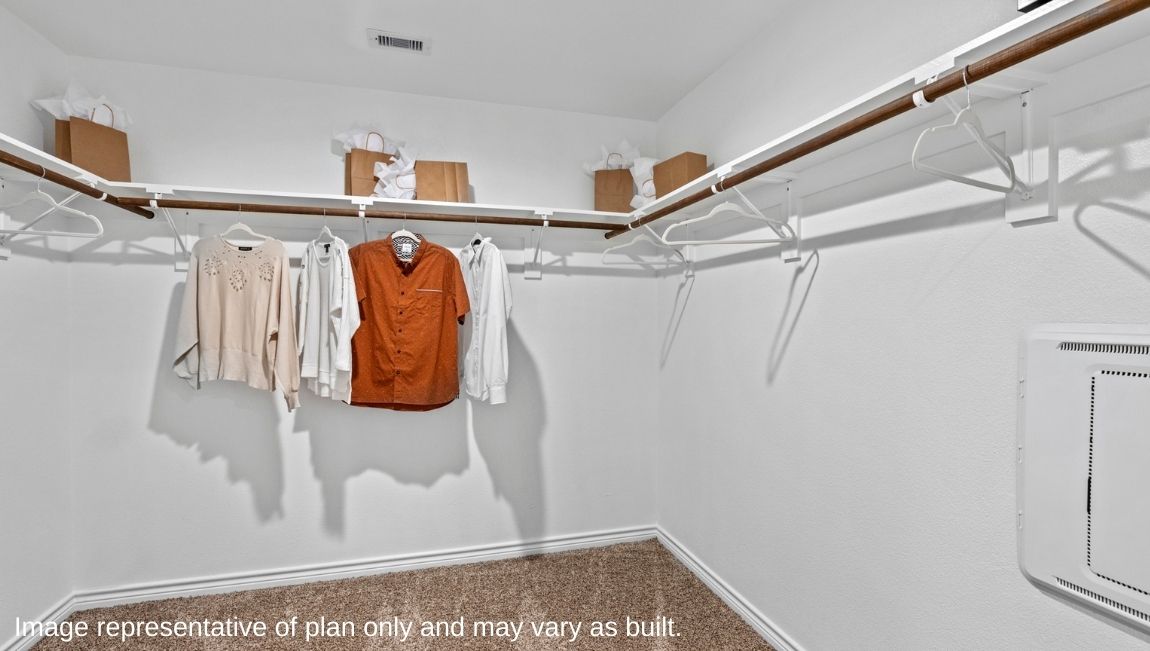 walk in closet located in primary bedroom suite