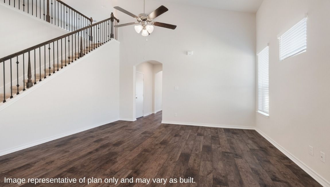 living room adjacent to staircase with iron railing.