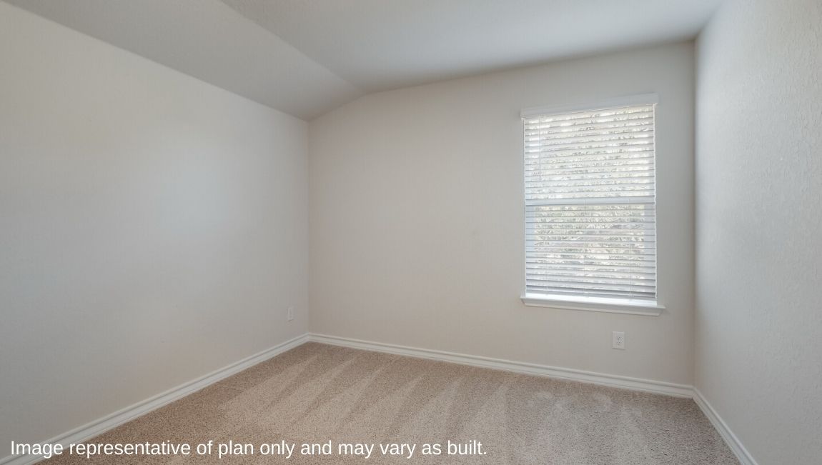 Third bedrooom with sloped ceiling, carpet flooring and window.