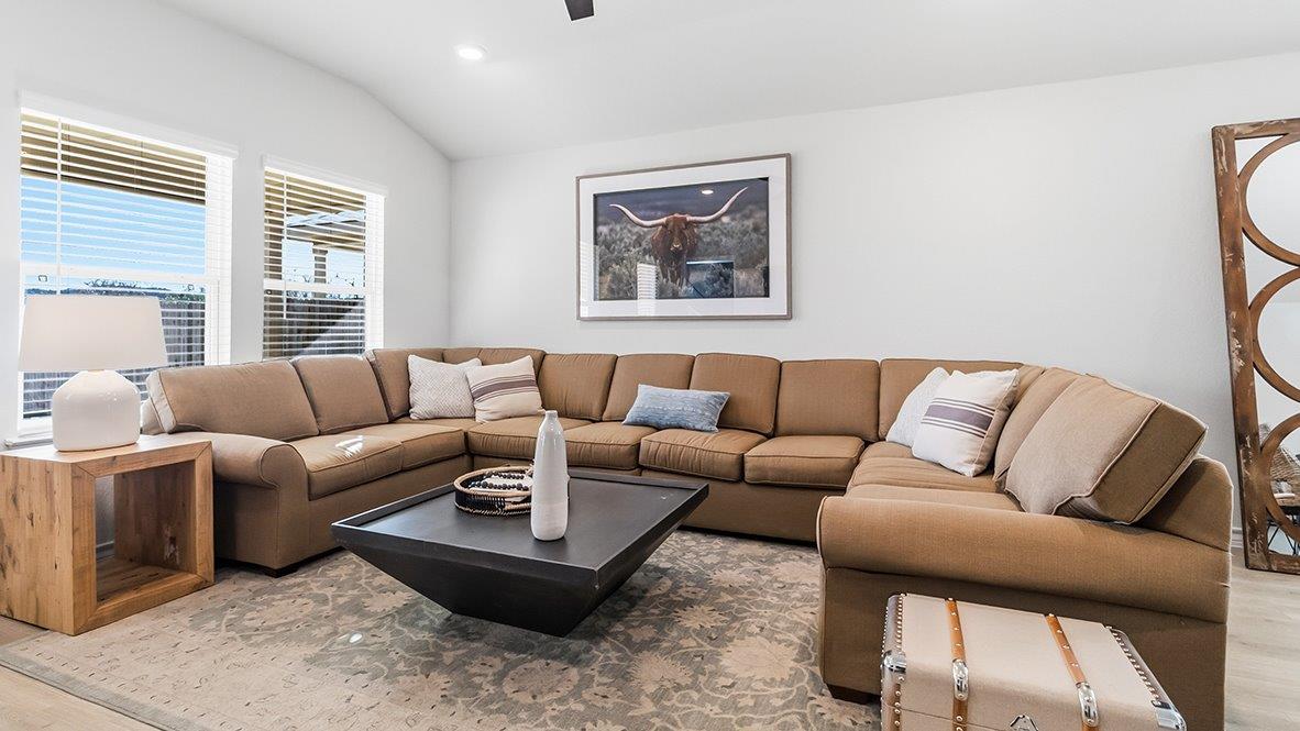 living room with ceiling fan and large windows