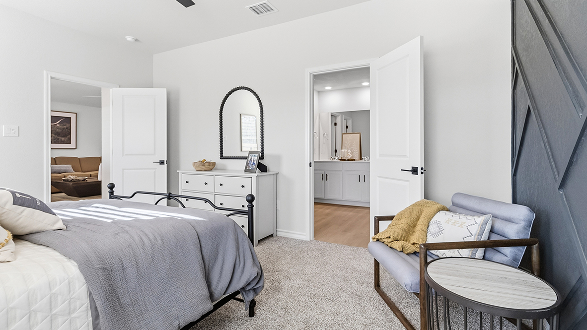 primary bedroom suite with accent wall and ensuite bathroom