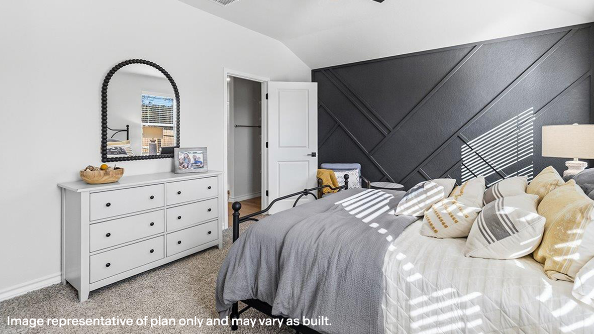 primary bedroom suite with accent wall and carpet