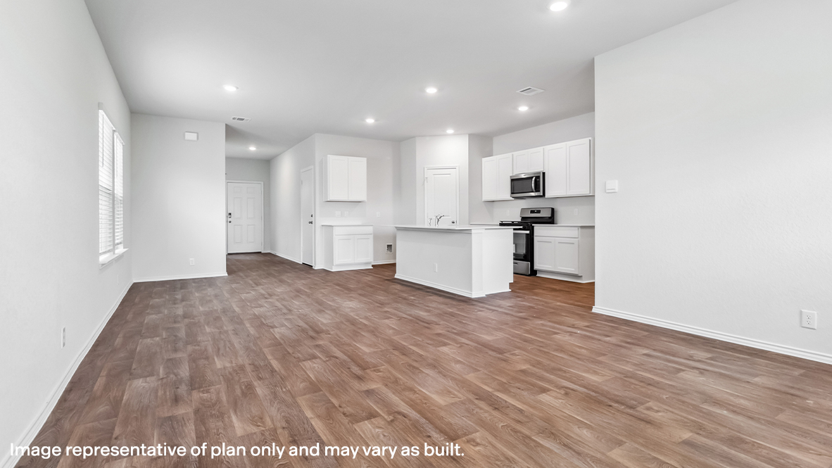 Open-concept dining area facing spacious kitchen with hard surface flooring.