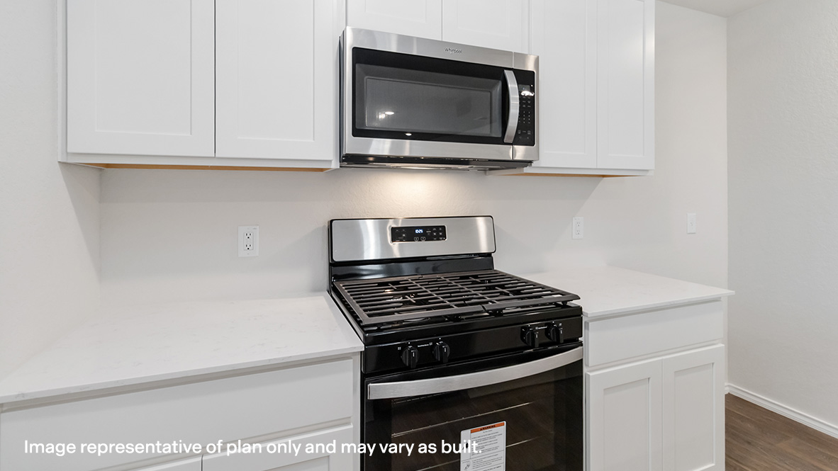 Kitchen with stainless steel appliances, gas range, shaker style cabinets and quartz countertops.
