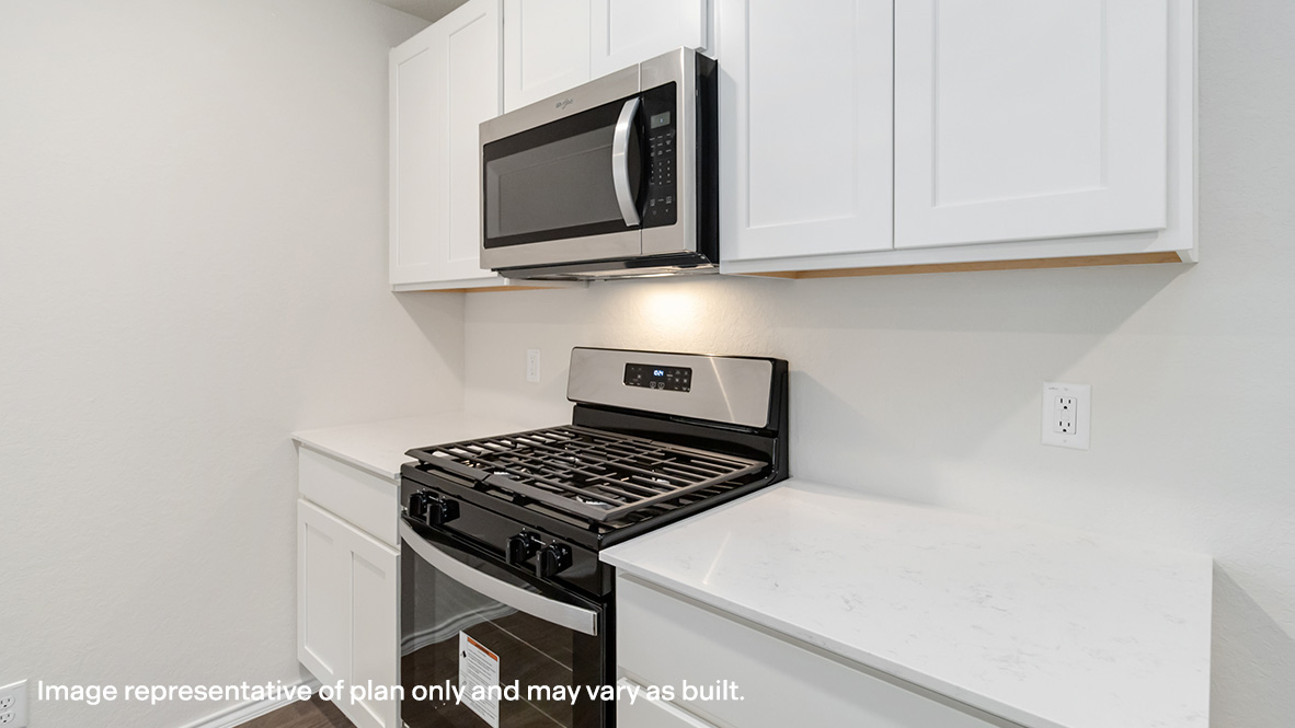Kitchen with stainless steel appliances, gas range, shaker style cabinets and quartz countertops.
