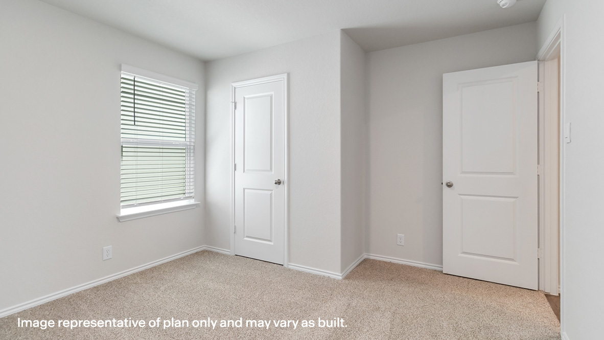 Fourth bedroom with carpet flooring, large window and walk-in closet.